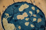 Antique Peking round rug's tattered edge and worn cobalt blue pile with beige leaves.