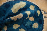 Antique Peking pictorial rug's short pile, expressive tree motifs, indigo blue, and tattered edge.