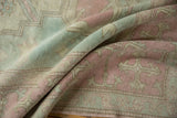 Distressed Oushak carpet texture showing faded pink, ivory, and powder blue tones.