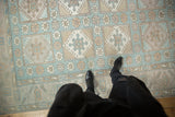 Distressed vintage Oushak rug with geometric paneled medallions and floral guls in pale blue and beige.