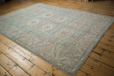Distressed border and geometric floral guls with even wear in pale blue, ivory, and mauve.