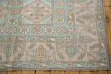 Distressed Oushak rug corner with floral guls and geometric borders, dusty blue, mauve.