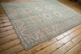 Distressed Oushak rug with geometric border details and pale floral guls.