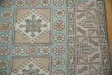 Distressed Oushak detail: pale blue, ivory, mauve geometric panels, floral guls, S-motifs.