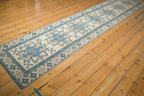 Distressed Oushak runner section showcasing denim blue geometric ram's horn and starburst motifs on ivory.