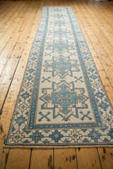 Ivory and blue geometric medallion with ram's horn motifs on distressed Oushak runner.