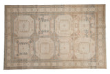 Distressed Sivas carpet, repeating geometric floral gul motifs in soft neutrals and faded dark blue.