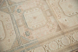 Close-up of distressed Sivas carpet, featuring faded blush, ivory tones, and geometric motifs with abrashes.