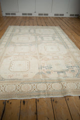 Distressed ivory, beige, and faded blue geometric motifs on a vintage Sivas carpet corner.