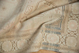 Distressed pile texture with faded beige, blush, and navy border details.