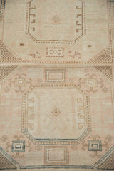 Close-up of the vintage Sivas rug's distressed geometric borders in ivory, blush, and beige.