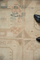 Distressed vintage Sivas carpet pile showing faded blush, ivory, and beige geometric motifs.