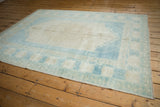 Distressed Oushak rug's intact side cord selvage with short pile and pale blue tones.