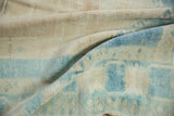 Distressed Oushak rug showing soft, short pile texture in ivory and pale blue.