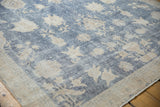 Distressed sky blue Sparta carpet with beige floral motifs showing wear to foundation.