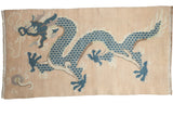 Vintage distressed Tibetan rug features dusty denim blue five claw dragon on pale peach.