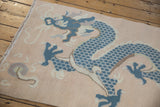Textured blue five-claw dragon detail on a pale peach distressed vintage Tibetan rug.
