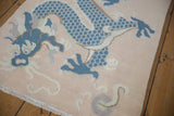 Pale peach vintage distressed Tibetan rug with dusty denim blue five claw dragon design.