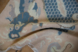 Softened, distressed pile texture with pale peach and dusty blue tones, highlighting original selvages.