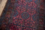 Vintage Lilihan rug's rich raspberry red field with sapphire blue floral pendant motifs.