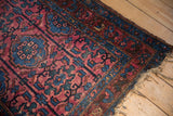Vintage Lilihan rug corner: tattered fringe, sapphire blue border, raspberry red floral motifs.