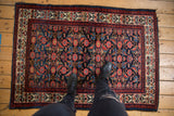 Vintage Malayer rug with abrashed indigo ground, Herati motif, and blossom border.