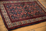 Vintage Malayer rug's indigo Herati field, cream blossomed border, and blue selvage.