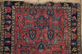 Vintage Lilihan rug: raspberry field, sapphire blue scrolling blossoms, and natural wear.