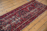Vintage Karaja runner's geometric field in cherry red and navy, showing tattered polychrome selvage.