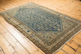 Vintage distressed Malayer rug corner showing worn side cord selvage and brown border.