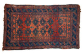 Antique Caucasian rug, brick red field, indigo blue borders, repeating gul and tribal motifs.