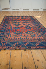 Geometric gul motifs and agricultural patterns in brick red and indigo on this antique Caucasian rug.