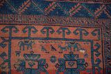 Geometric gul, stylized animal motifs, and serrated border on the antique Caucasian rug.