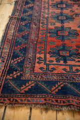 Geometric indigo border and brick red field of antique Caucasian rug, showing mostly even wear.