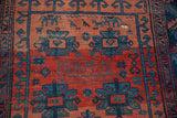 Antique Caucasian rug detail: indigo geometric motifs, weaver inscription 1908, brick red field, even wear.