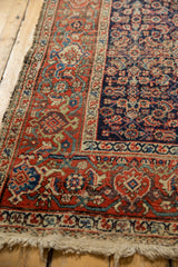 Antique Persian Fereghan carpet's brick red border, navy Herati field, and aged pile.