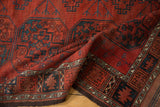 Folded antique Ersari carpet: chestnut red field, navy gul, ivory border, even wear.