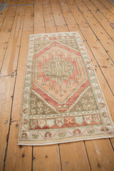Close-up of distressed Oushak rug showing central serrated medallion and germinating plant motifs.