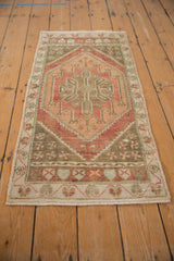 Distressed Oushak rug detail: serrated medallion, dusty raspberry, and ivory floral border.