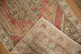 Distressed Oushak rug runner corner showing worn pile texture and hand-knotted foundation.