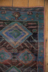 Hand-knotted Oushak rug corner, revealing distressed denim blue, mallard green diamond patterns.