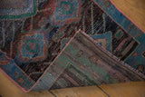 Distressed pile texture with charcoal and blue shades, revealing the hand-knotted rug's woven reverse.