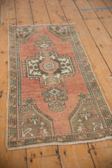Vintage distressed Oushak rug detail: geometric medallion, floral motifs, dusty rose, sandalwood tones.