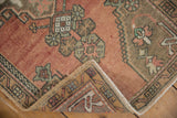 Folded corner of the vintage Oushak rug, showing fringed ends, intact selvages, and even pile wear.