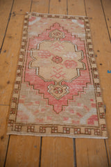 Distressed Oushak rug detail, pink and ivory floral medallion with low pile texture.