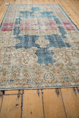 Distressed Oushak runner section featuring denim blue, fuchsia, and ivory scrolling palmette motifs.