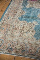 Distressed Oushak runner's worn blue field and pale scrolling palmette border.
