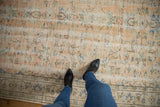 Distressed Oushak rug's worn apricot and seafoam green field underfoot.