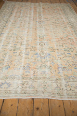 Distressed Turkish Oushak rug surface, wear to knot heads, pale apricot, seafoam green vinery.
