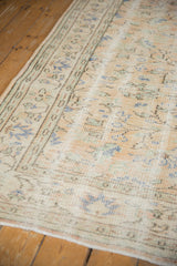 Distressed Oushak carpet with faded apricot, ivory, and seafoam green scrolling vinery.